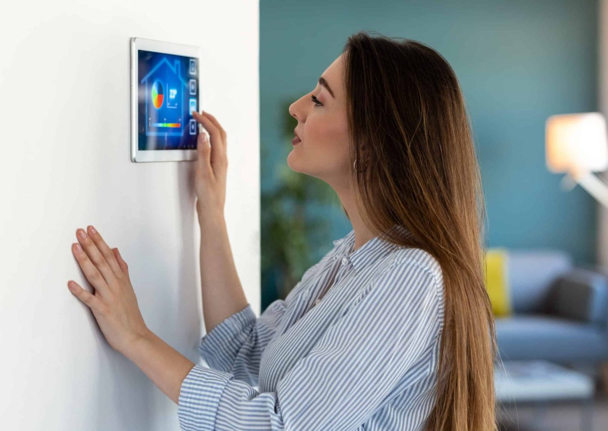 Shot of pretty young woman using the home automation system on digital tablet to regulate the temperature.
